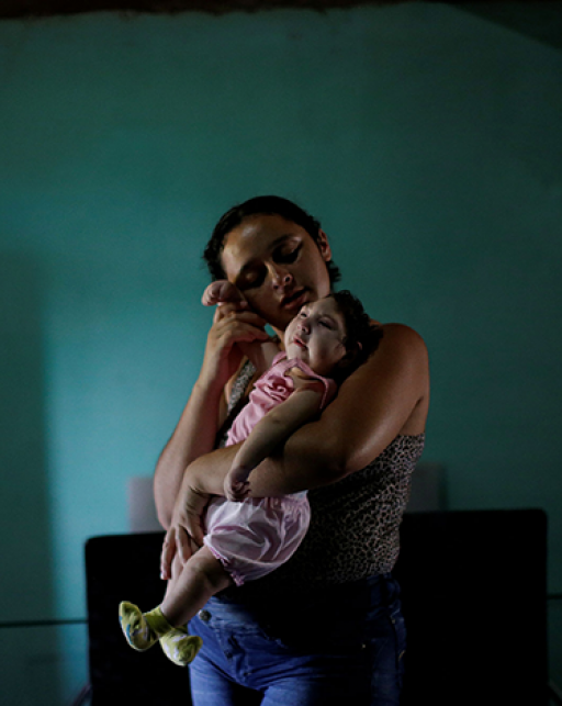 Uma mãe segura um bebê com microcefalia, Brasil