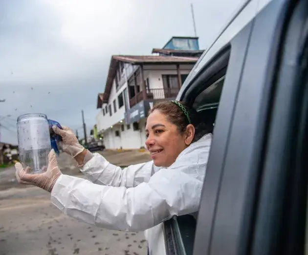 Agente de Controle de Endemias libera mosquitos de um carro para o world mosquito program