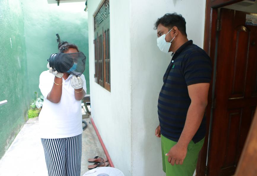 Um membro da equipe do WMP explica como funciona uma armadilha para mosquitos a Kasun Chameera